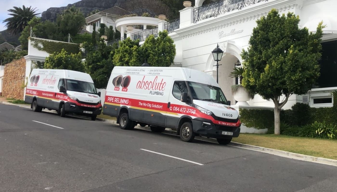 Absolute Plumbing Vans outside a residence
