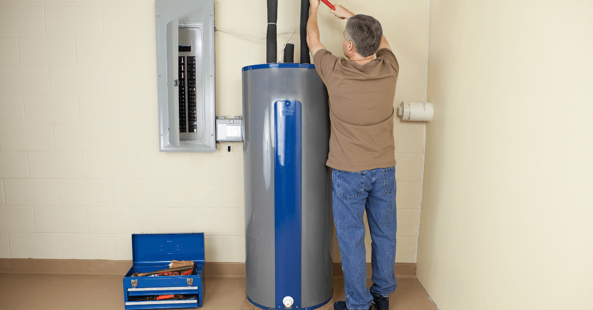 A Plumber installing a large electric geyser 