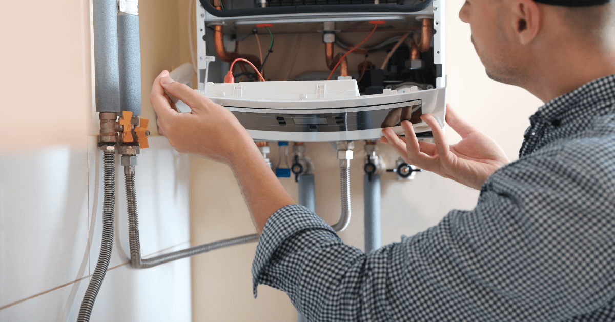 Technician inspecting the internal components of a gas geyser 