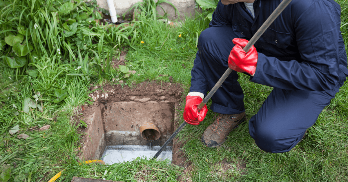 Plumber clearing a residential drain through a access point 